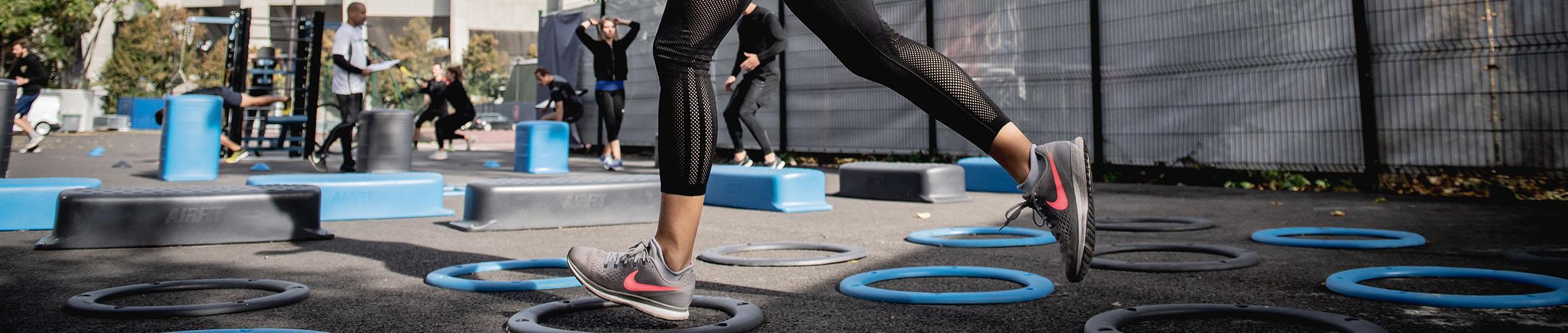 People working out outdoors and close up on feet doing a circuit course.