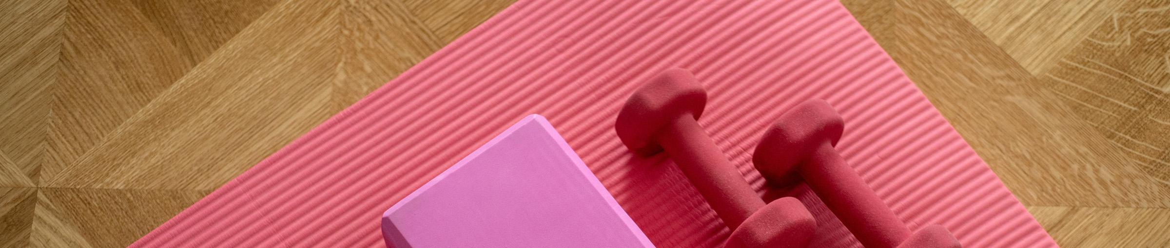 Pink dumb bells and yoga mat