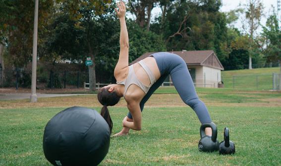 Woman doing a pre-workout stretch in a park.