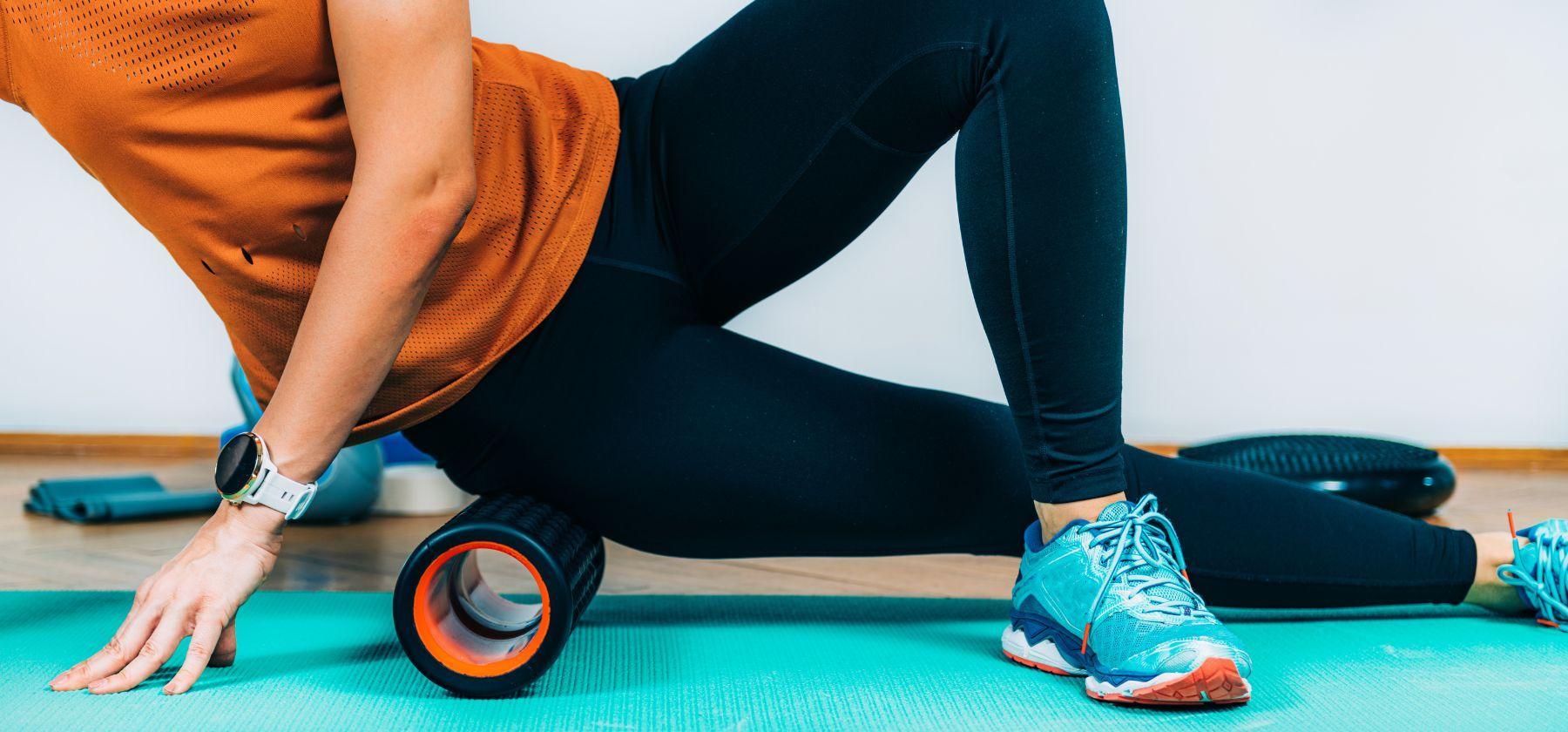Woman using foam roller on leg