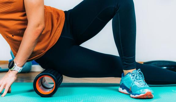 Woman using foam roller on leg