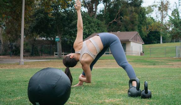 Woman doing a pre-workout stretch in a park.